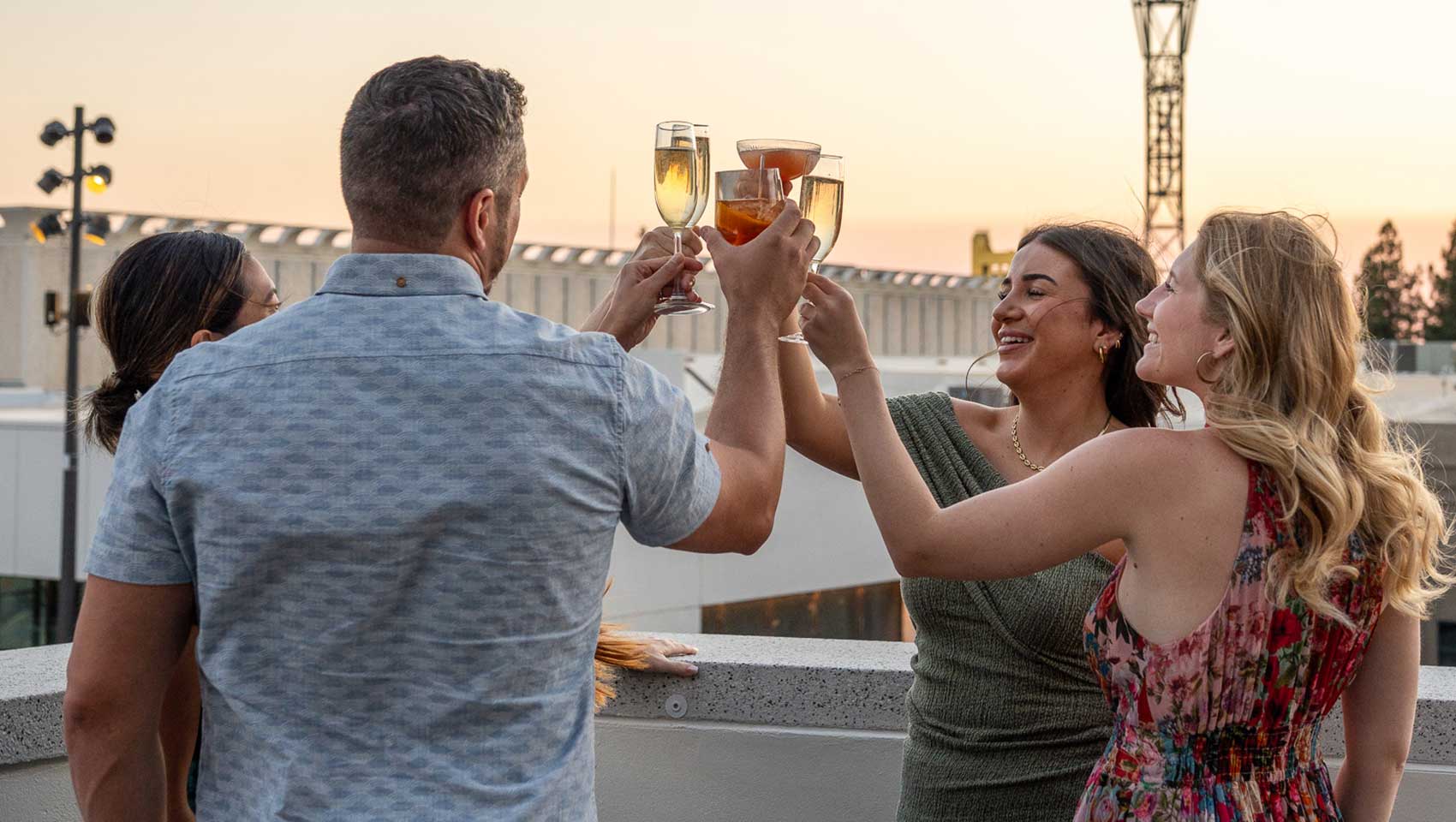 group of friends toast at sunset on Kimpton sawyer rooftop