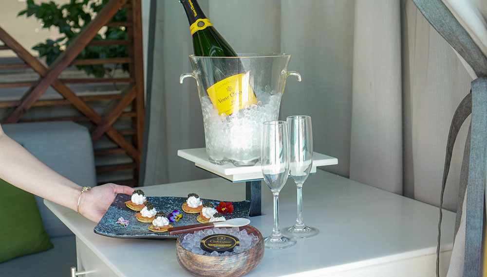 table in a cabana at Kimpton sawyer hotel with Champagne on ice, blinis and caviar